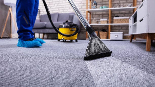 person cleaning blue carpet